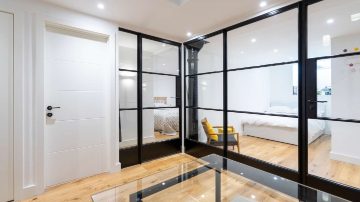 Stylish internal steel doors and screens in a modern home, enhancing light flow between living areas and a bedroom. Perfect for contemporary designs.