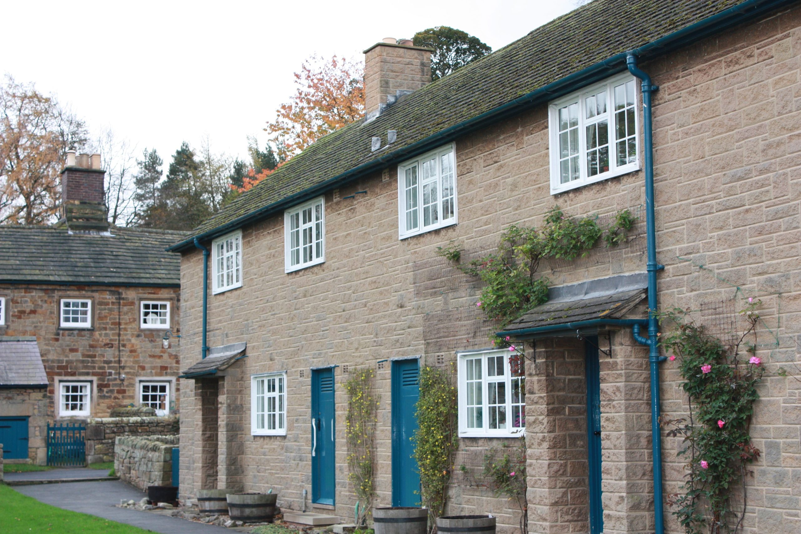 A traditional English country cottage with blue doors and white windows